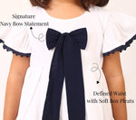 White cotton dress for girls with navy bow detail